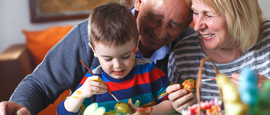 Grandmother and grandfather with grandson preparing eggs for Eas